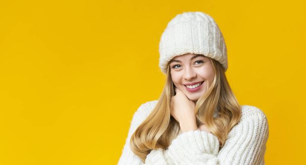 Vonzó mosolygós lány portréja fehér kötött téli kalapban - Fotó, kép