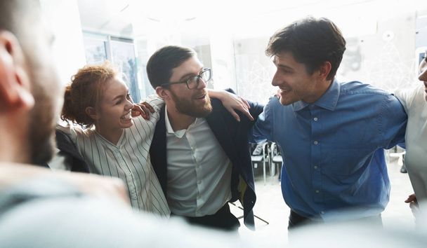 Iloiset liikemiehet kiertävät ympyrää yritysseminaarissa
 - Valokuva, kuva