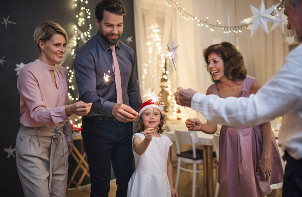 Small girl with parents and grandparents indoors celebrating Christmas. - Φωτογραφία, εικόνα