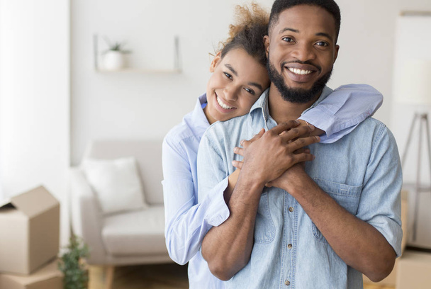 Black Couple Hugging Standing In New Apartment - 写真・画像