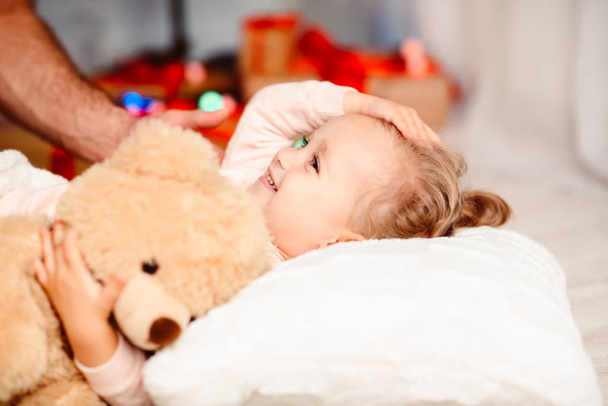 Adorable niñita va a dormir en la noche de Navidad
 - Foto, Imagen