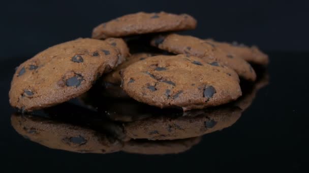 Biscotti al cioccolato su sfondo nero elegante e una superficie a specchio
 - Filmati, video