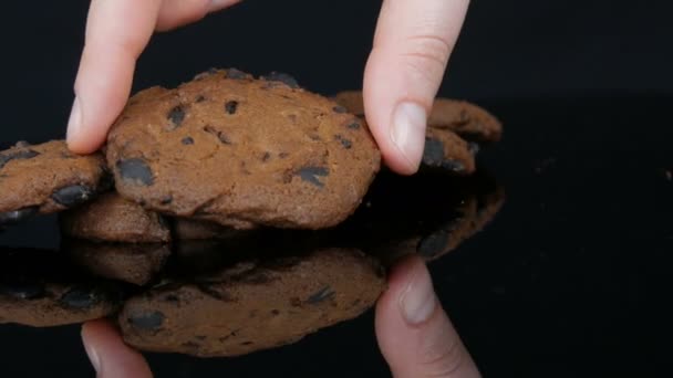 Schokoladenkekse auf stilvollem schwarzen Hintergrund und Spiegeloberfläche - Filmmaterial, Video