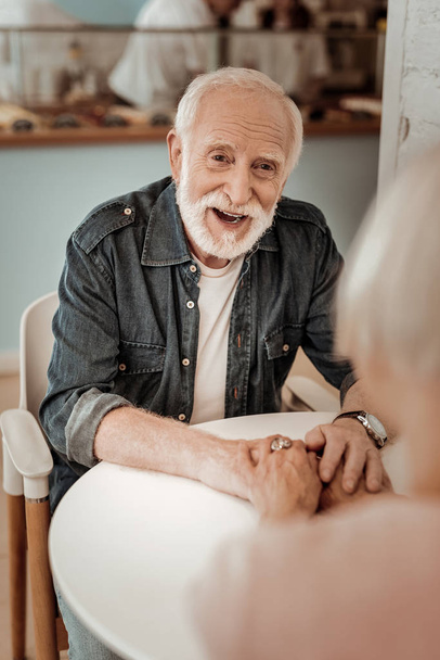 Positive elderly man smiling while looking at his wife - Fotoğraf, Görsel
