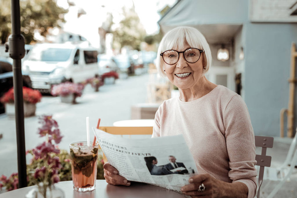 Joyful happy woman reading a morning newspaper - Foto, afbeelding