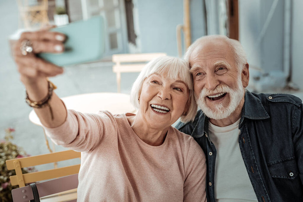 Happy aged couple taking a selfie together - Foto, afbeelding