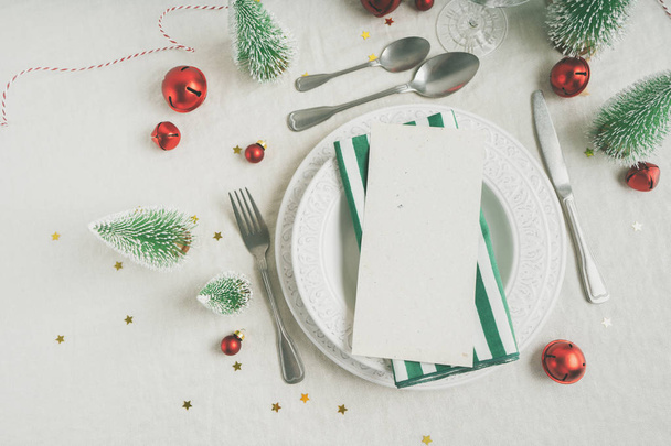 Beautiful table setting on grey background with white plates, glass, cutlery silverware, champagne and Christmas decorations. Holiday layout with copy space. - Foto, afbeelding