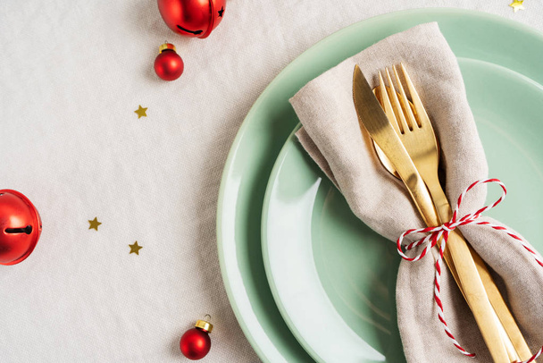 Close view of golden cutlery on light napkin for Christmas table setting. - Foto, Bild