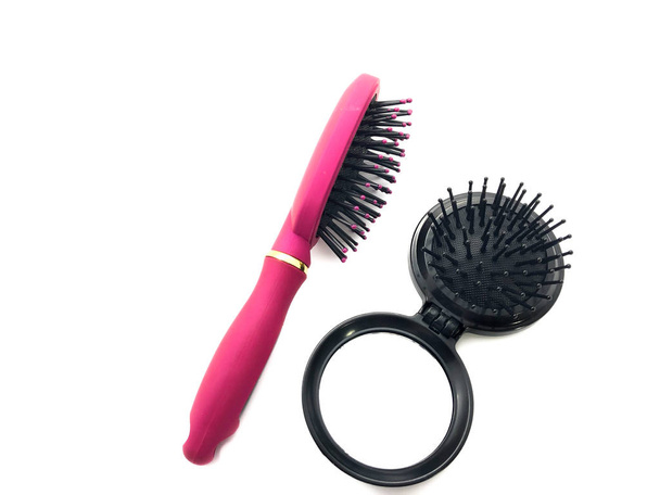 Black comb with a mirror isolated on white background. A small mirror with a comb for a handbag. Stylish mirror. Pink hairbrush. - Photo, Image