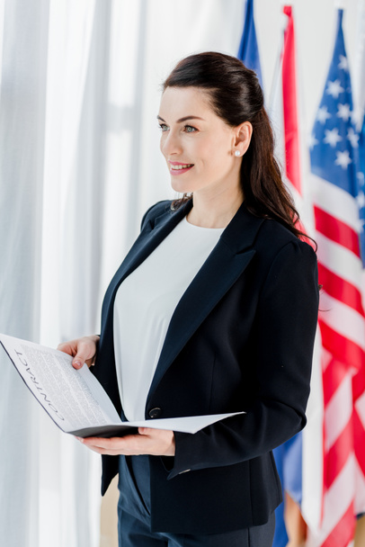 diplomata feliz segurando pasta com contrato perto da bandeira americana
  - Foto, Imagem