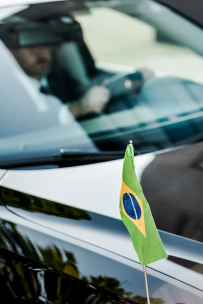 selective focus of brazilian flag near man in modern car  - Photo, Image
