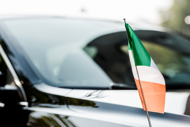 επιλεκτική εστίαση της ιρλανδικής σημαίας κοντά στο σύγχρονο μαύρο αυτοκίνητο  - Φωτογραφία, εικόνα