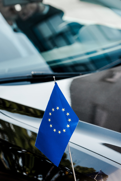 επιλεκτική εστίαση της σημαίας της Ευρωπαϊκής Ένωσης κοντά στο μαύρο αυτοκίνητο  - Φωτογραφία, εικόνα