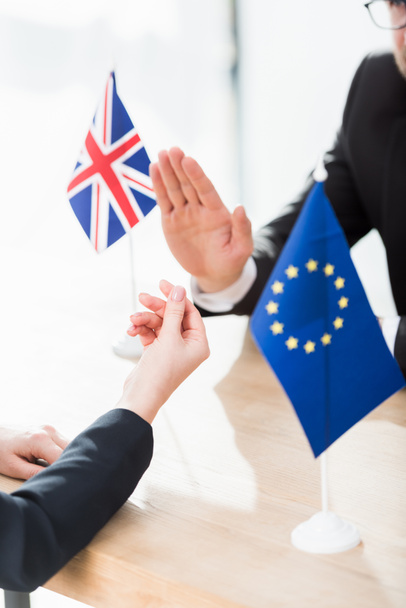 обрезанный взгляд дипломата Европейского союза на денежный жест возле посла Соединенного Королевства
 - Фото, изображение