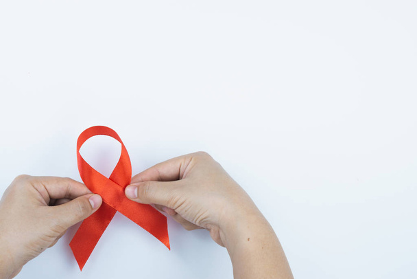 Aids consapevolezza, mani maschili in possesso di nastro rosso di consapevolezza AIDS su
  - Foto, immagini