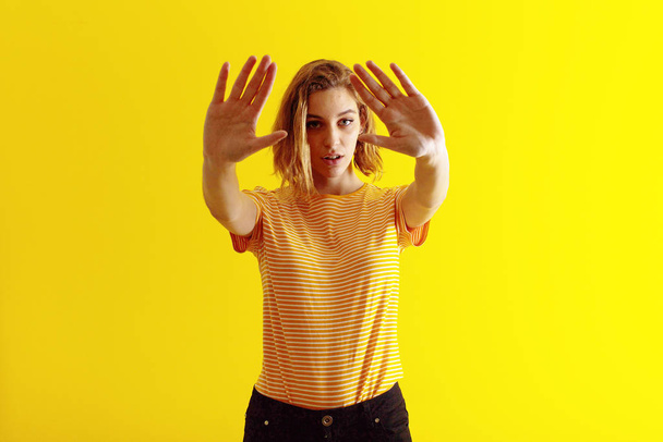 young blonde woman  against flat color wall - Photo, image