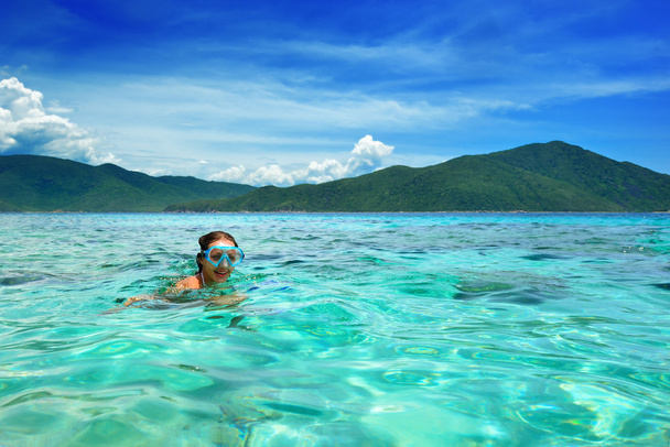 Счастливая девушка в маске плавает в лазурном тропическом море
 - Фото, изображение