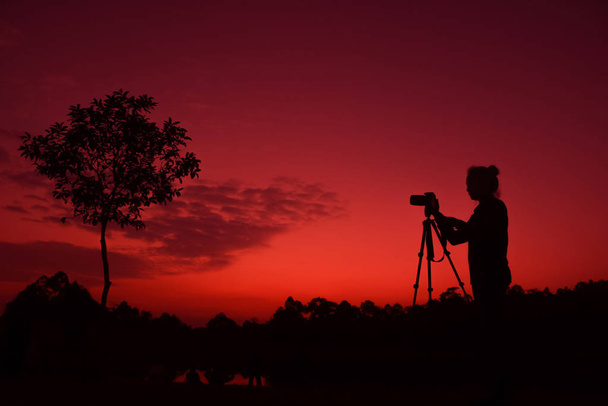 Fotograaf neemt foto 's buiten, silhouet van een vrouw met - Foto, afbeelding