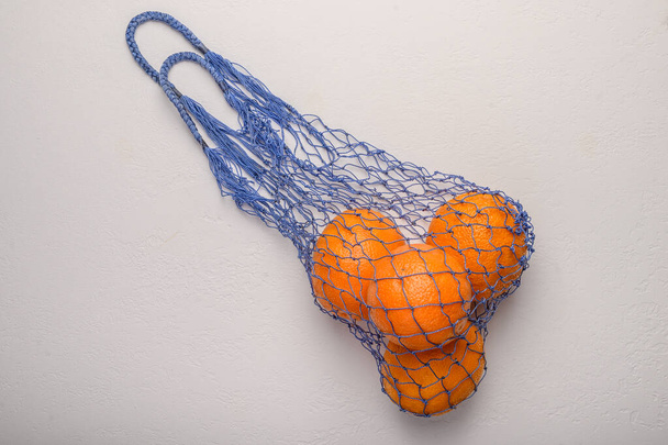 Oranges in a mesh string bag made of natural material. Environmental protection - Foto, afbeelding