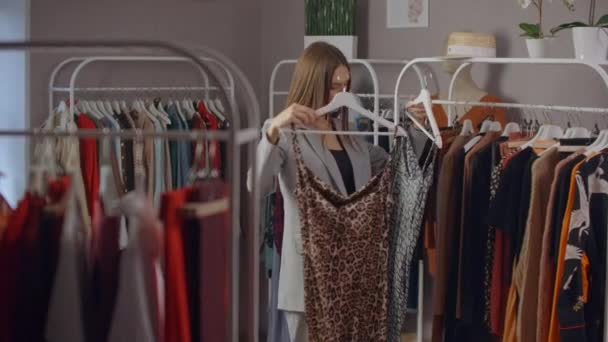 Verkauf - Frau im Kleiderladen wählt ein Kleid - Einkaufskonzept. Nahaufnahme - Filmmaterial, Video