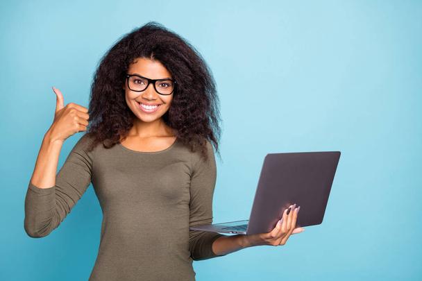 Portrait of confident cool smart mulatto girl hold use laptop show thumb-up like her job feel she clever intelligent real professional wear stylish green sweater isolated over blue color background - Fotoğraf, Görsel