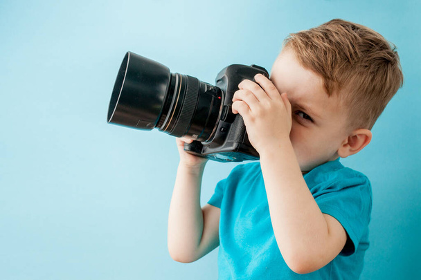 Little boy with camera on a blue background - Zdjęcie, obraz