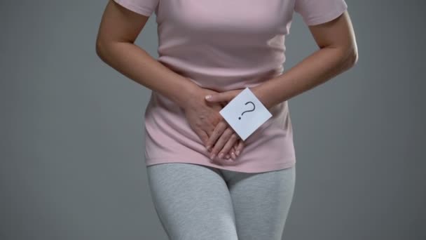 Lady with question mark sign on her hand touching belly, cystitis, dysmenorrhea - Footage, Video