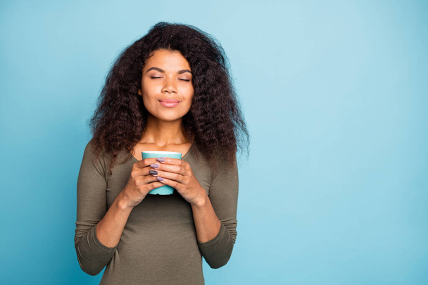 Portrait of charming positive afro american girl hold cup mug with hot tea smell aroma of caffeine beverage feel peaceful calm wear style jumper isolated over blue color background - Foto, afbeelding