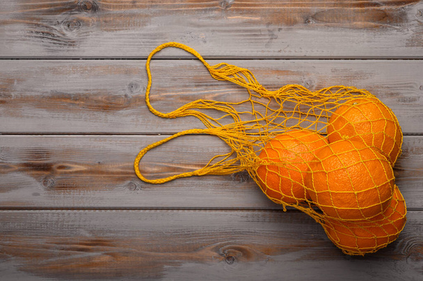 Oranges in a mesh string bag made of natural material. Environmental protection - Foto, immagini