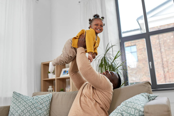happy african american father with baby at home - Foto, afbeelding