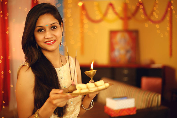 Retrato de una hermosa joven india en vestido de sari tradicional celebrando el festival diwali con fondo decorativo con motivo de Diwali, Retrato de estudio
. - Foto, imagen