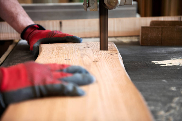 Asztalos vágás egy fa deszka egy szalagfűrésszel - Fotó, kép