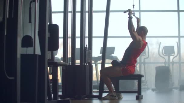 Shoulder pull down machine. Man working out lat pulldown training at gym. Upper body strength exercise for the upper back. Fit male doing cross training at gym. - Footage, Video
