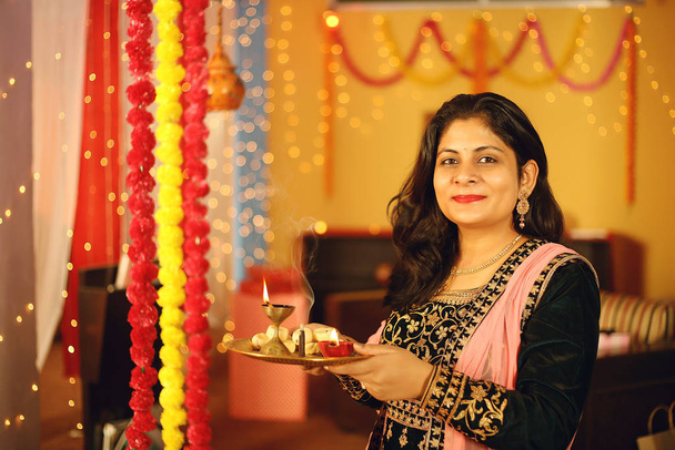 Retrato de una hermosa joven india en vestido de sari tradicional celebrando el festival diwali con fondo decorativo con motivo de Diwali, Retrato de estudio
. - Foto, imagen
