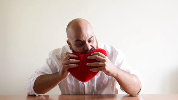Crazy funny bearded man eating heart and falling in love - Footage, Video