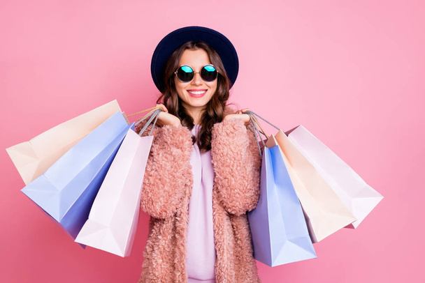 Photo of pretty millennial model lady carry many packs shopper enjoy tourism abroad sales wear fluffy jacket sun specs vintage blue hat isolated pink background - Photo, image