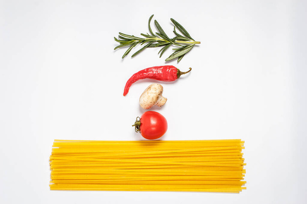 Raw pasta, fresh vegetables, tomatoes and mushrooms on a white plate close - Foto, afbeelding