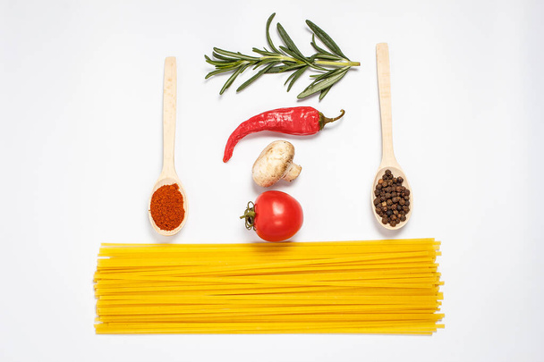Raw tasty pasta with vegetables and spices on a white background - Foto, imagen