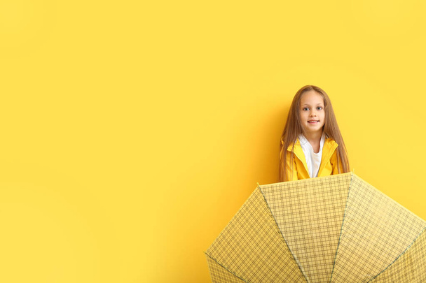 Модная маленькая девочка в осенней одежде и с зонтиком на цветном фоне
 - Фото, изображение