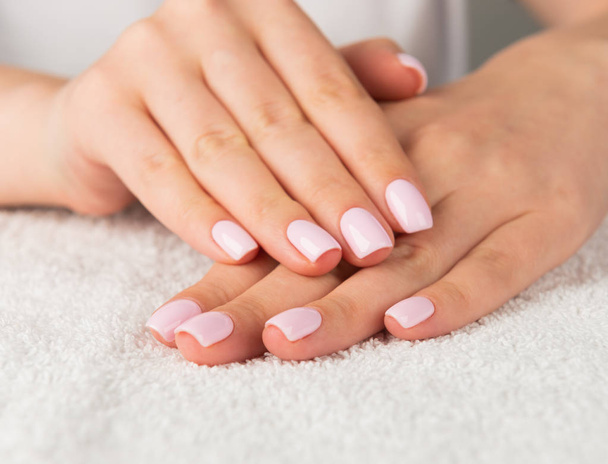 Beautiful female hand with light pink nail design - Fotografie, Obrázek