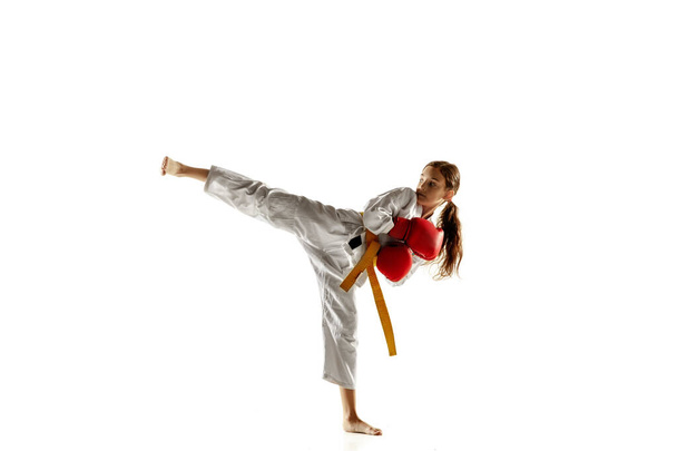 Confident junior in kimono practicing hand-to-hand combat, martial arts - Foto, Imagen