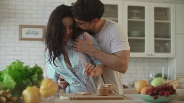 Lovely couple flirting at home. Sensual woman flirting with man at kitchen - Felvétel, videó