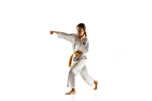 Confident junior in kimono practicing hand-to-hand combat, martial arts - Photo, Image