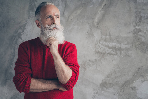 Photo of attractive aged guy holding hand on chin looking thoughtful empty space wear red knitted pullover hipster santa clothes isolated grey color wall background - Φωτογραφία, εικόνα