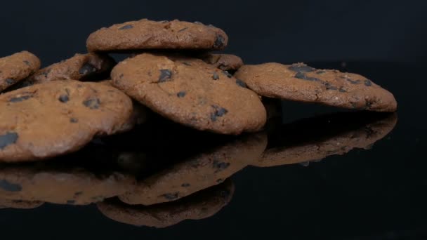 Schokoladenkekse auf stilvollem schwarzen Hintergrund und Spiegeloberfläche - Filmmaterial, Video