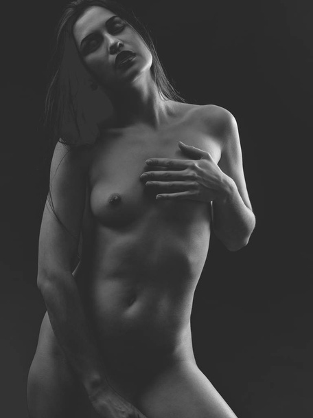 Nude woman over dark background - Foto, Imagem