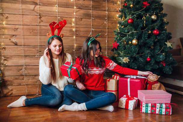 Two caucasian beautiful woman holding gift boxes. Christmas and New year celebration party concept. - Фото, изображение