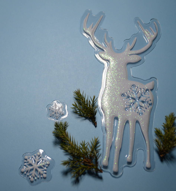 Weihnachtskarte. auf blauem Hintergrund, frische Zweige von Fichten, Hirschen und weißen Schneeflocken. - Foto, Bild