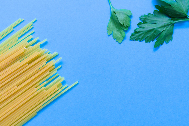 spaghetti on a blue background, top corner with rosemary - Photo, Image