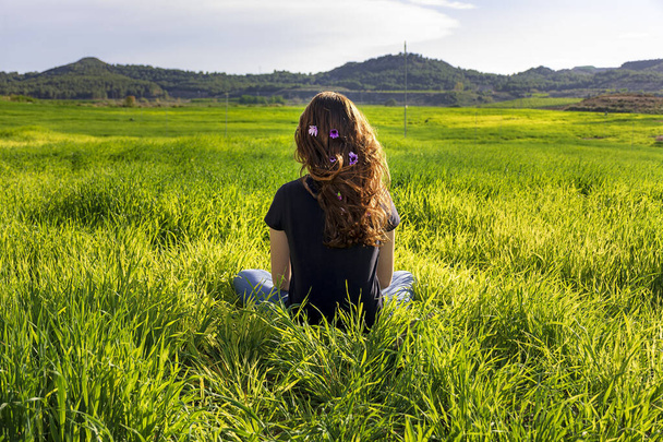 Mladá bělovlasá zrzavá žena s dlouhými vlasy a pihami seděla na trávě v poloze jógy. bdělost, meditace a relaxační scéna - Fotografie, Obrázek